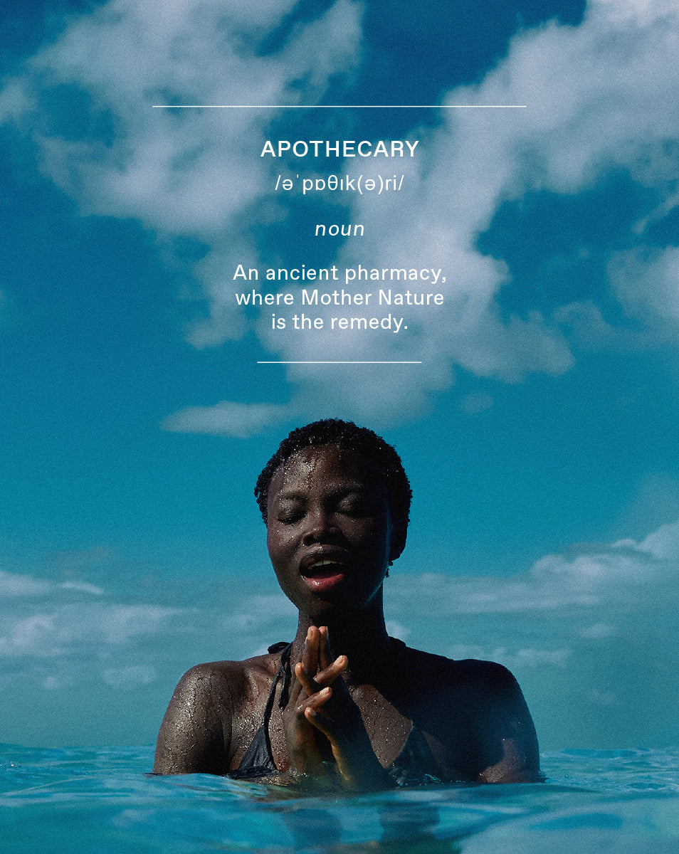 A woman in open water, eyes closed, hands pressed together — stillness and ritual